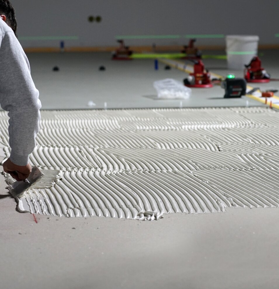 Apply tile adhesive on the floor for large format tiles